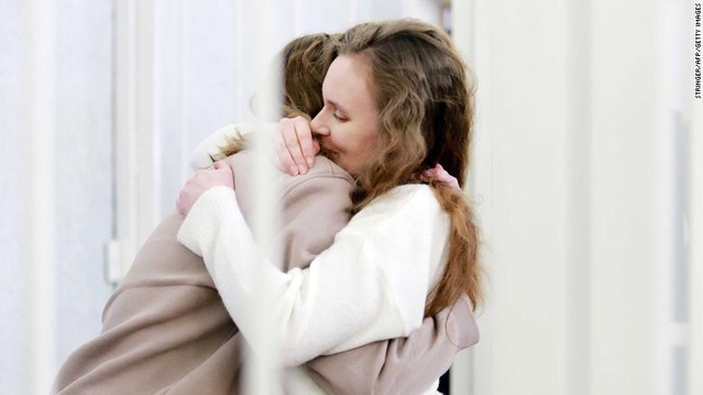 Belsat TV journalists Yekaterina Andreyeva (right) and Darya Chultsova (left) embrace each other in a defendant's cage during their trial in Minsk on 18th February